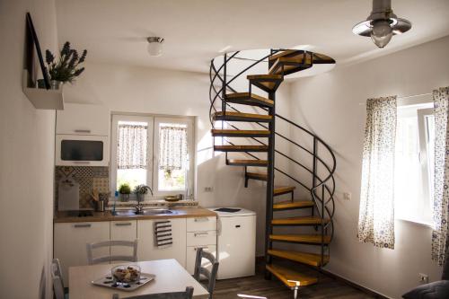 Una escalera de caracol en una cocina junto a una mesa en Apartments by the sea Sveti Filip i Jakov, Biograd - 16966, en Sveti Filip i Jakov