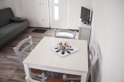 a white table and chairs in a living room at Apartments by the sea Sveti Filip i Jakov, Biograd - 16966 in Sveti Filip i Jakov