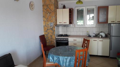 eine kleine Küche mit einem Tisch, einem Tisch und Stühlen in der Unterkunft Apartments with WiFi Olib - 16674 in Olib