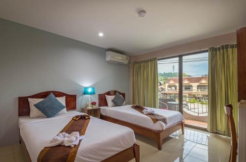 a hotel room with two beds and a balcony at Mookanda Residence in Ao Nang Beach