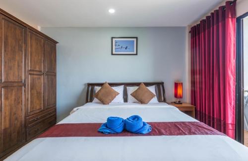 a bedroom with a bed with two blue shoes on it at Mookanda Residence in Ao Nang Beach