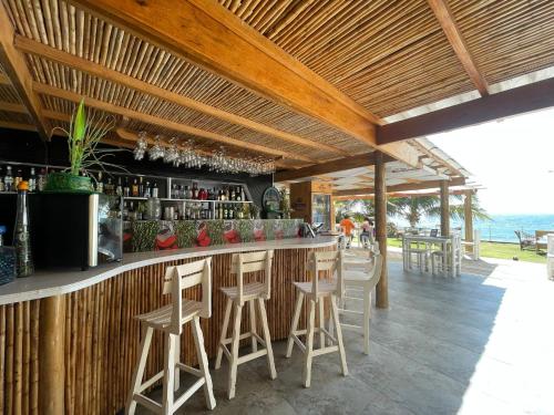 un bar con taburetes en un bar con vistas al océano en Sunset Mancora, en Máncora