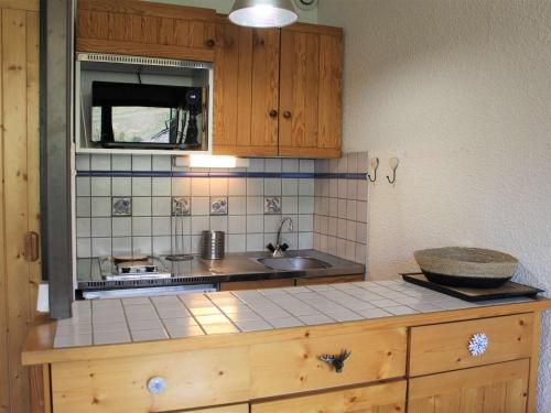 uma cozinha com um lavatório e uma bancada em Appartement Vars, 1 pièce, 4 personnes - FR-1-330B-197 em Vars
