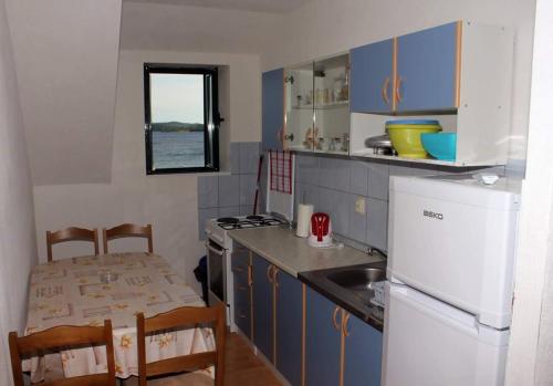 eine Küche mit blauen Schränken und einem weißen Kühlschrank in der Unterkunft Apartments by the sea Orebic, Peljesac - 16883 in Orebić