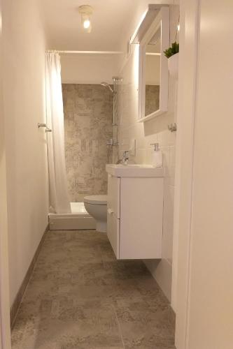 a white bathroom with a sink and a toilet at Double Room Njivice 17010a in Njivice