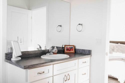 uma casa de banho branca com um lavatório e um espelho em NEW CONDO Cache Valley 3BR 2BA - Sleeps 7 em Logan