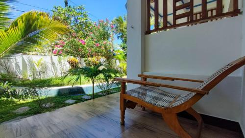 a rocking chair on a porch with a view of a garden at Aqua Blue in Arugam Bay