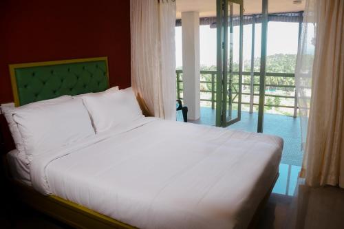 1 dormitorio con cama blanca y ventana grande en Aanandakosha Ayurveda Retreat, en Trivandrum