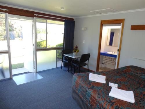 ein Hotelzimmer mit einem Bett und einem Tisch in der Unterkunft Gayndah A Motel in Gayndah