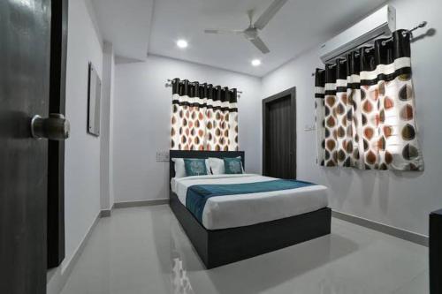 a bedroom with a bed in a white room at HOTEL SRIRAMA INN in Gachibowli