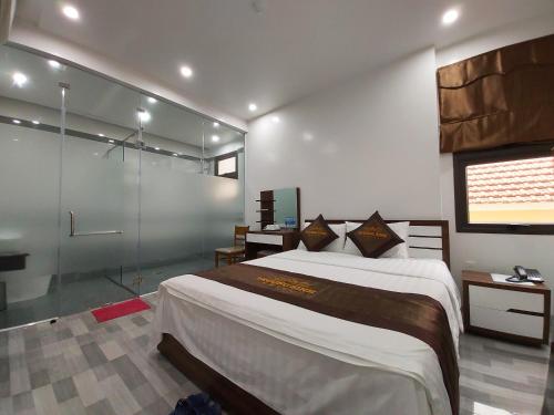 1 dormitorio con 1 cama grande y ducha de cristal en Trường Sinh Hotel, en Hai Phong