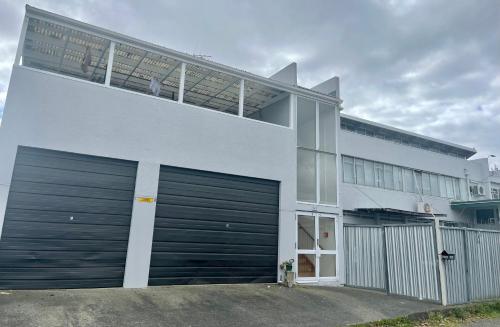 a large white building with two garage doors at Kamo Studio Apartment in Whangarei