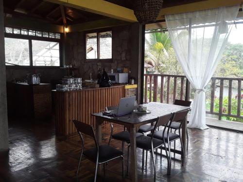 a kitchen with a table and chairs with a laptop on it at Maremonti Vacation Rental in Puerto López