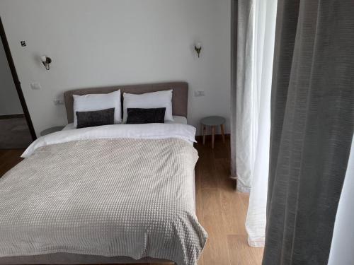 a bedroom with a large bed with white sheets and pillows at Transylvania House in Moieciu de Jos