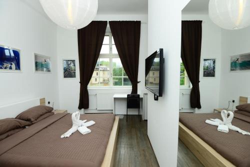 two beds in a room with a window at Galeria Rooms in Ljubljana