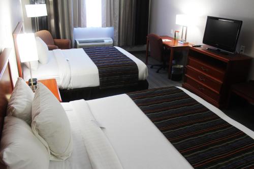 a hotel room with two beds and a television at Country Inn & Suites by Radisson, Lackland AFB San Antonio, TX in San Antonio