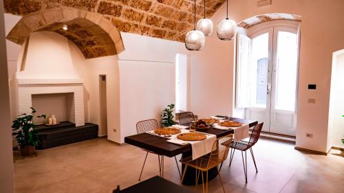 a dining room with a table and chairs and a fireplace at Casa Minerva - Suite e Relax in Gioia del Colle