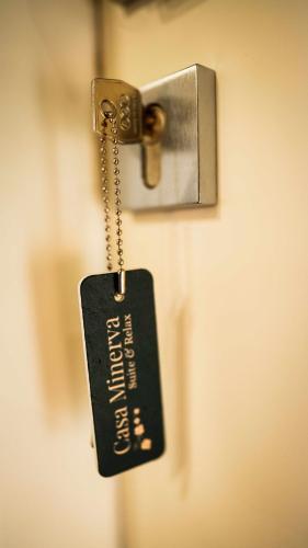 a key tag hanging from a door latch at Casa Minerva - Suite e Relax in Gioia del Colle