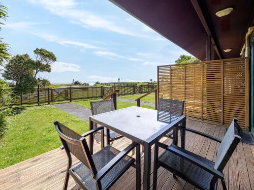 a patio with a table and chairs on a deck at Shining Star Beachfront Accommodation in Hokitika