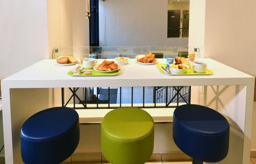 a table with plates of food and two chairs at ibis budget Nice Aeroport in Nice