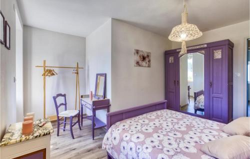 a bedroom with a purple bed and a desk at 3 Bedroom Stunning Home In Baraqueville in Baraqueville
