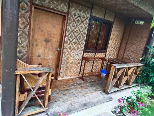 a wooden door leading to a room with a wooden bench at Allba's Homestay in Moalboal