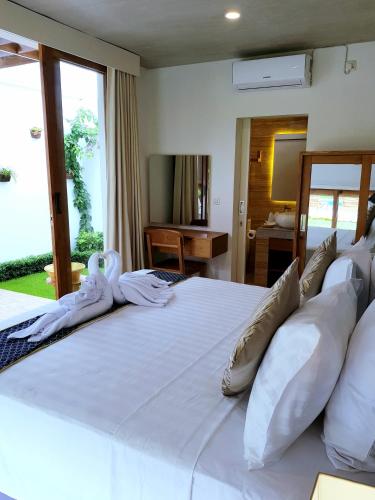 a large white bed with white sheets and pillows at The Edicha in Lovina