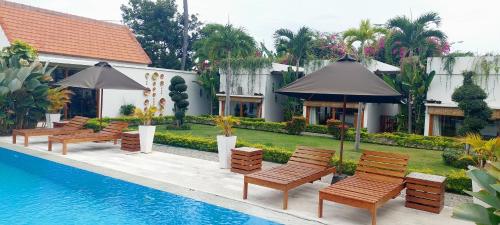 a group of chairs and umbrellas next to a pool at The Edicha in Lovina