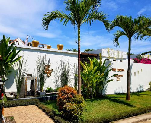 un bâtiment blanc avec des palmiers devant lui dans l'établissement The Edicha, à Lovina