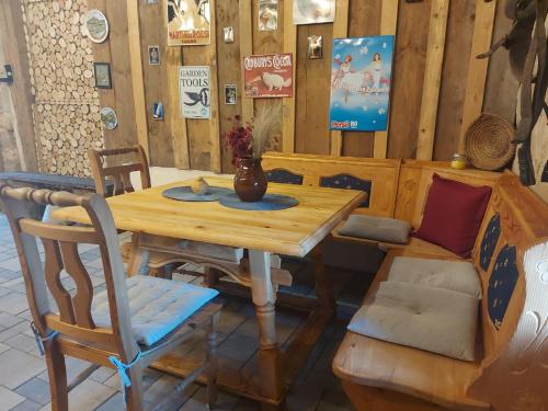 a table and chairs in a room with wooden walls at Ferienwohnung Zu den Weinbergen in Zeil