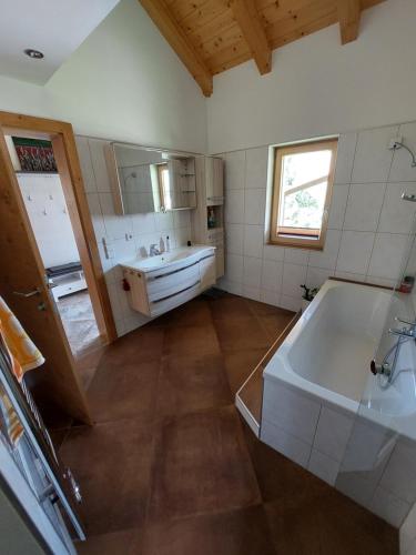 ein großes Bad mit einer Badewanne und einem Waschbecken in der Unterkunft Fewo Baurechthof in Goderschach