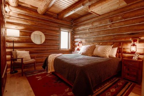 a bedroom with a bed in a log cabin at Classic Log Cabin near Rocky Mountain National Park and near Skiing in Lyons