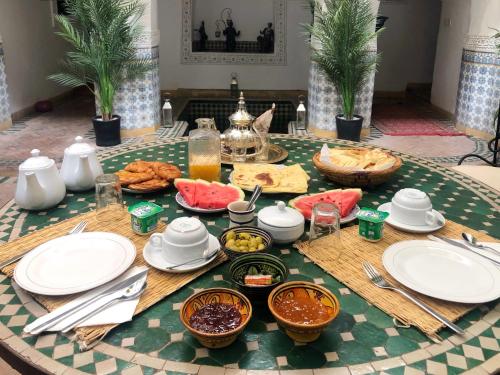 een tafel met borden en kommen met eten erop bij Riad Al Mamoune in Marrakesh