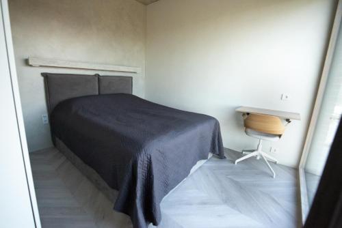 a bedroom with a bed and a table and a desk at MARINIS Luxury Apartments - Svencelės Vėjai - 1st line by the Lagoon in Svenele