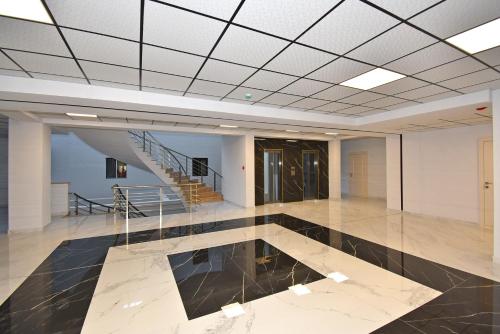 a large empty room with a staircase and a lobby at Apartroom in Tsaghkadzor