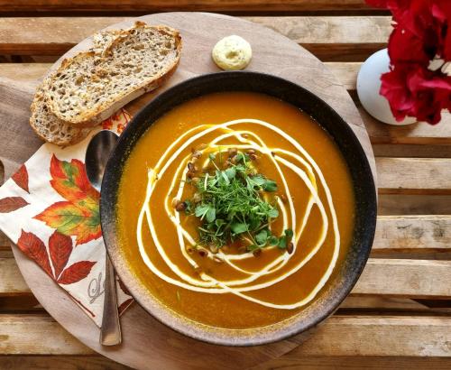 a bowl of soup with pasta and a slice of bread at Fugl Fønix Hotel in Etnesjøen