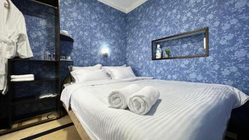 a blue bedroom with a bed with towels on it at FRОDО - Cozy as a home for 4-6 persons in Tashkent