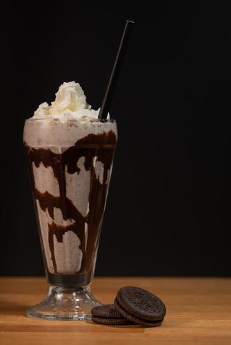 a chocolate milkshake in a glass on a table at Fugl Fønix Hotel in Etnesjøen