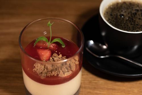 a dessert in a glass next to a cup of coffee at Fugl Fønix Hotel in Etnesjøen