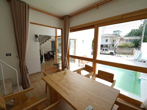 a room with a table and chairs and a large window at RIM HuaHin Villa By RoomQuest in Hua Hin