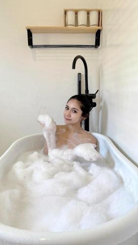 a woman is sitting in a bath tub at RIM HuaHin Villa By RoomQuest in Hua Hin