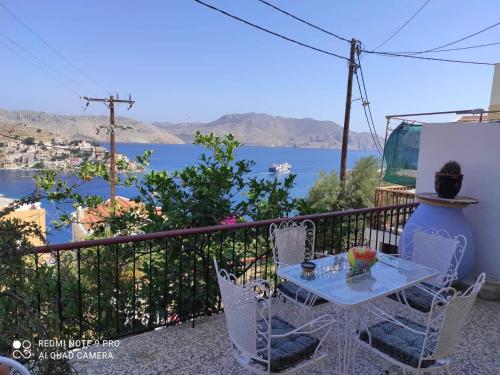 a table and chairs on a balcony with a view of the water at Giorgina's house: Aegean view in Symi