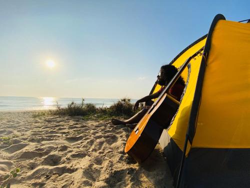 a man sitting in a tent on the beach at Secret Bay Panama in Arugam Bay