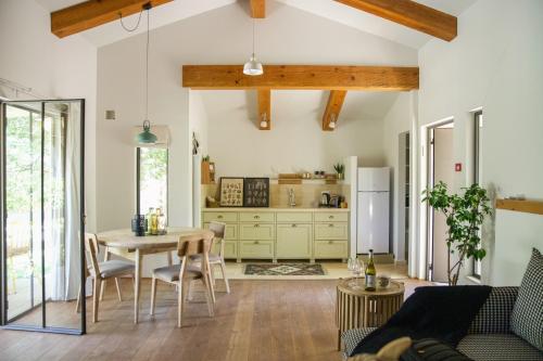 a living room with a table and a kitchen at Hanahala Beramot - Boutique Suites in Moshav Ramot