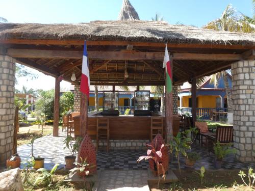 a pavilion with a table and chairs and flags at Bohobé Naboty in Toliara