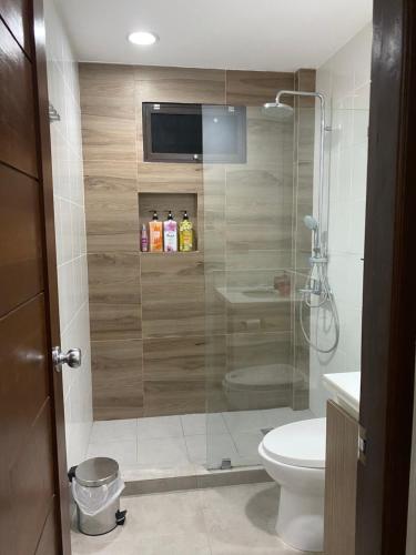 a bathroom with a shower with a toilet and a sink at Vivere Condominium in Vigan