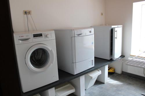 een wasruimte met een wasmachine en droger op een aanrecht bij Chez Arsène in Bouillon