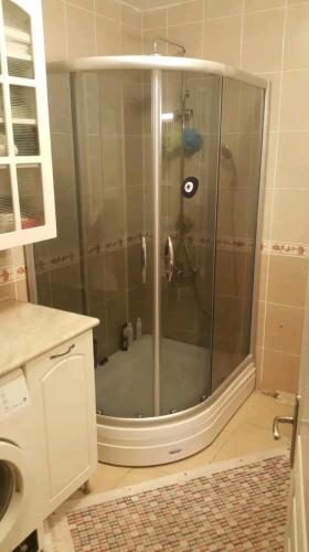 a shower with a glass door in a bathroom at Comfortable Layover from 12 mins Istanbul Airport in Istanbul
