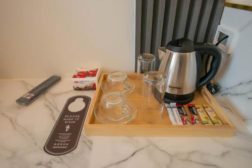 a wooden tray with a coffee maker on top of a counter at Hotel Agnes in Buriram
