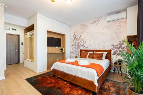 een slaapkamer met een bed en een tv aan de muur bij Glamour Apartments 8 in Boekarest